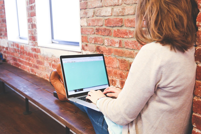 Woman on laptop sitting on bench